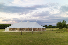 A marquee set up in a field in the evening for an event like a wedding or a party